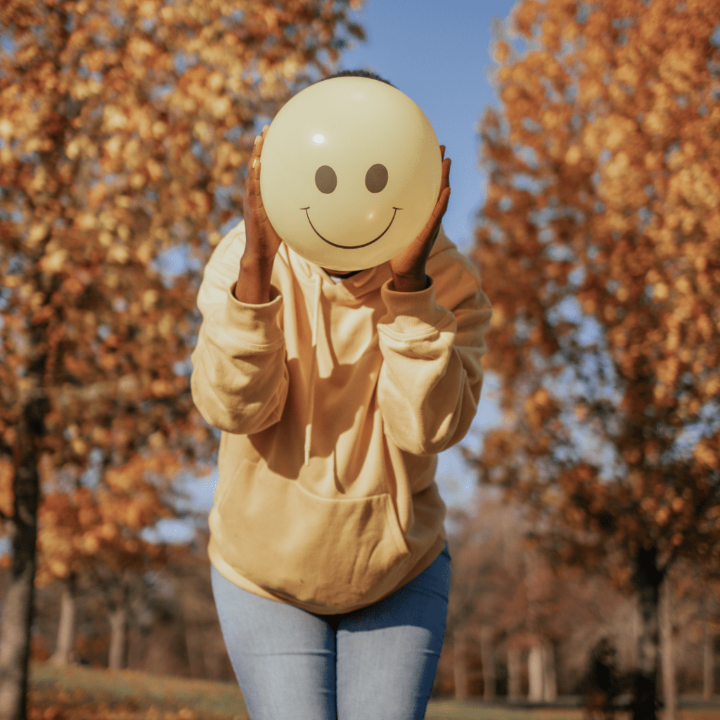 Kobieta trzyma balon z uśmiechniętą buzią