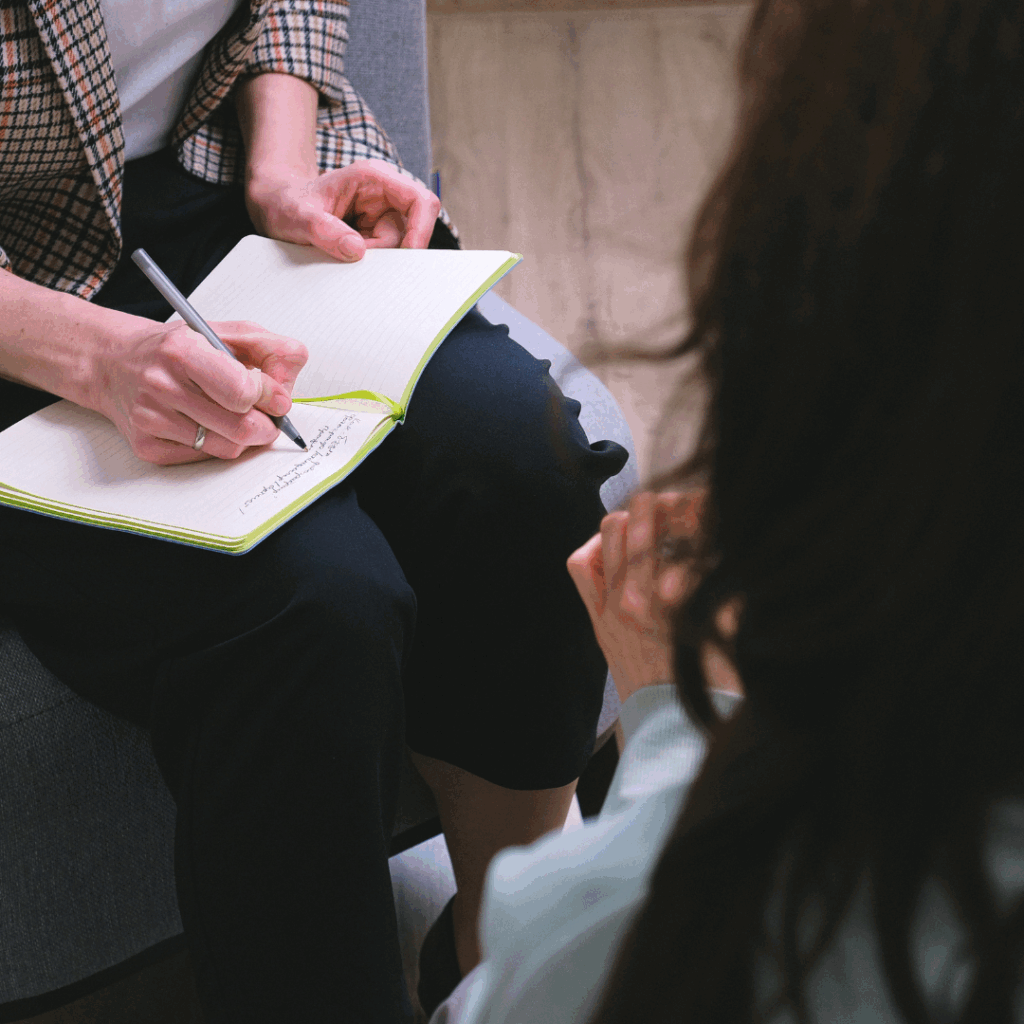 Psychoterapia indywidualna– psycholog robi notatki podczas spotkania z pacjentem